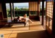 A naked woman laying on a wooden table in a room.