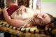 A woman laying on top of a bed with pearls around her neck.