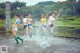 A group of young women playing with a soccer ball in the water.