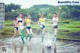 A group of young women playing with a soccer ball in the water.