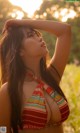 A woman in a bikini standing in a field.