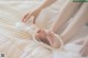 A woman is laying on a bed with her feet up.