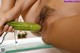 A woman is holding a cucumber in her mouth.