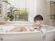 A woman laying in a bathtub in a bathroom.