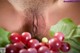 A close up of a woman's butt with a bunch of grapes.