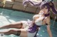 A woman in a purple and white outfit is sitting in a pool.