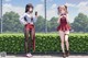 A couple of girls standing next to each other near a fence.