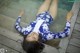 A woman laying on the edge of a swimming pool.