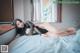 A woman laying on top of a bed in a black dress.